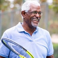 smiling man with tennis racket